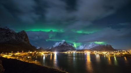 Northern lights over a bayside village at night