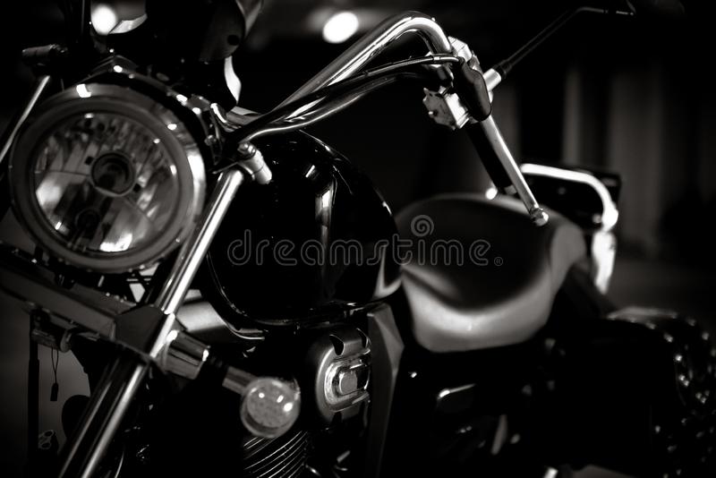 Black and white vintage photo of chopper bike details chromed with soft light and reflections with side leather bags stock photo