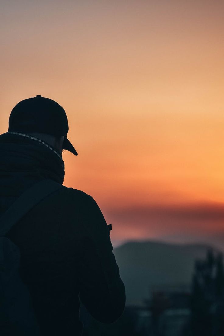 Man wearg baseball cap and backpack at golden hour photography poses for men man photography dark photography