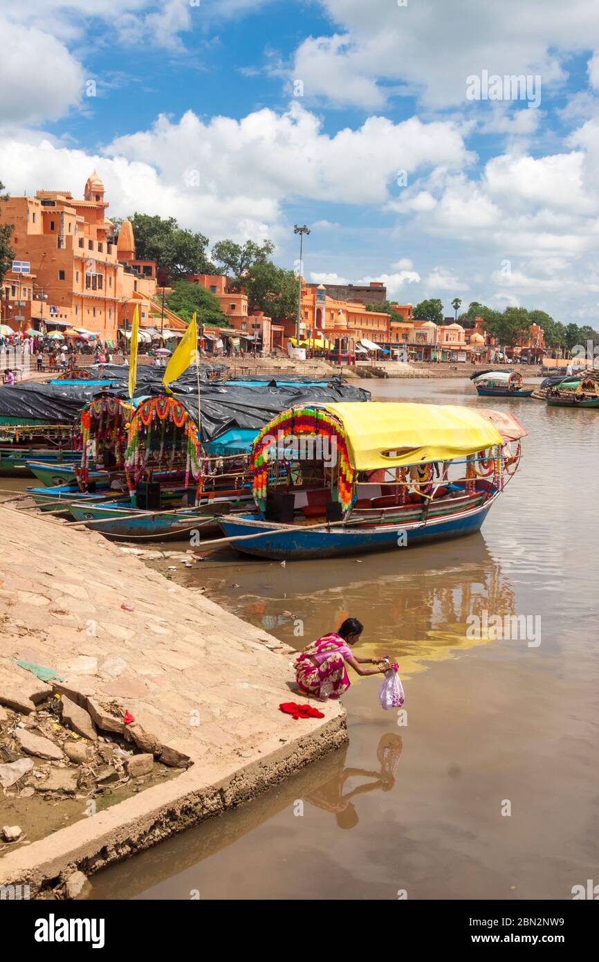 Chitrakoot madhya prash indien eine frau tut wãsche durch die bunten boote die nahe n schritten von ramghat auf m mandakini fluã sãumen stockfotografie