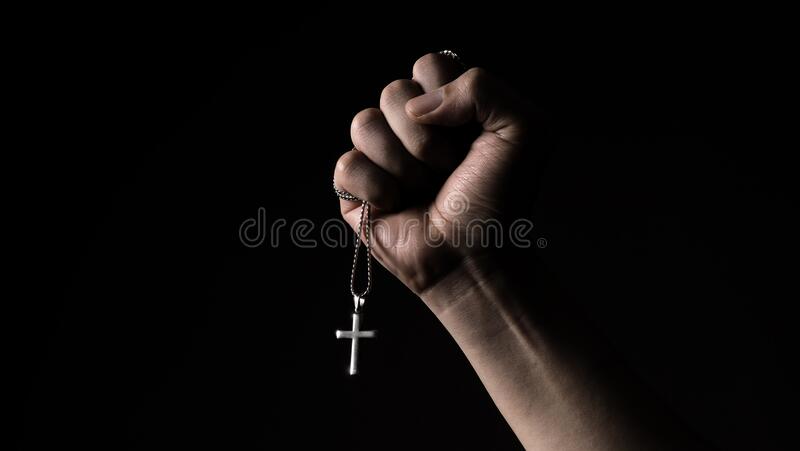 Silver crucifix or cross pendant and necklace on body or hand stock image