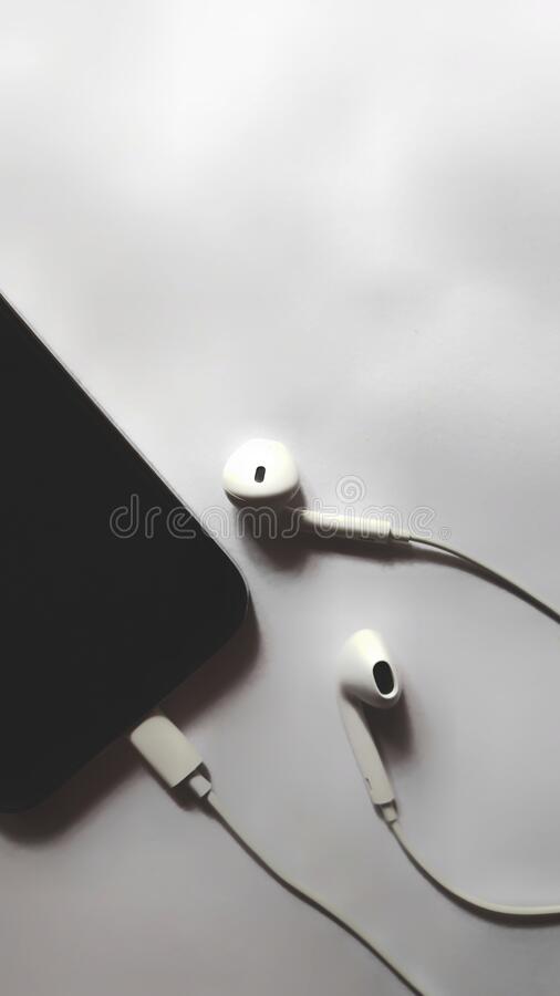 White earphones with mobile headphones wallpapers in black background wallpaper photos stock image