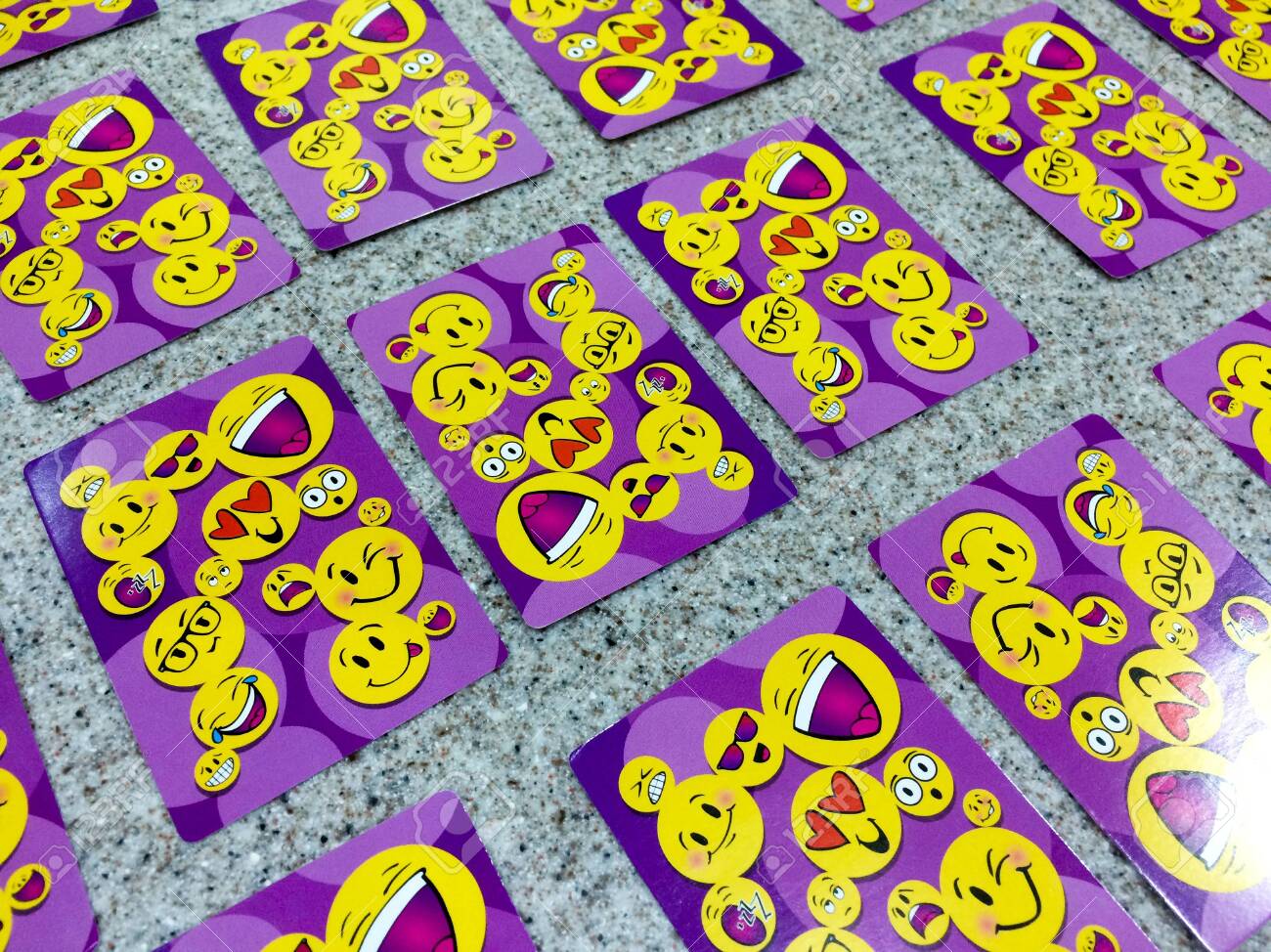 Happy face smiely emoji on playing cards purple color on table stock photo picture and royalty free image image