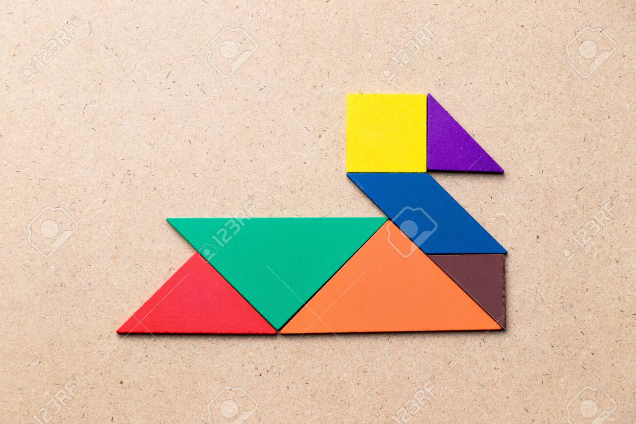 Color tangram in duck swan or goose shape on wood background stock photo picture and royalty free image image