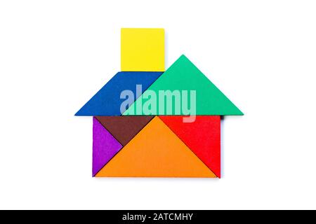 Color tangram puzzle in house or home shape on wood background stock photo