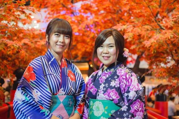 Premium photo young woman wearing japanese traditional kimono in autumn color japan