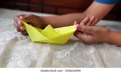 Kid making paper boat yellow color stock photo