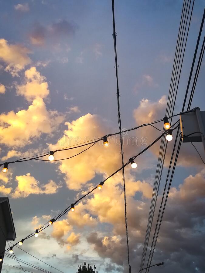 Blue sky with pink and orange clouds aesthetic tumblr background wallpaper with fairy lights stock image