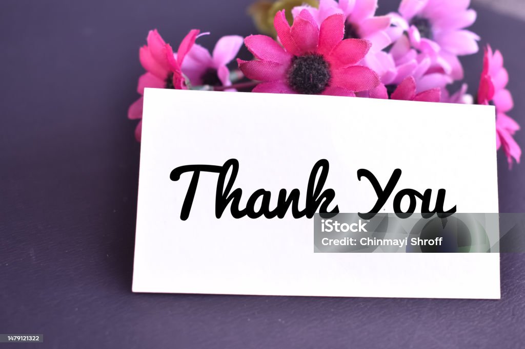 A closeup picture of a thank you card with pink flowers stock photo