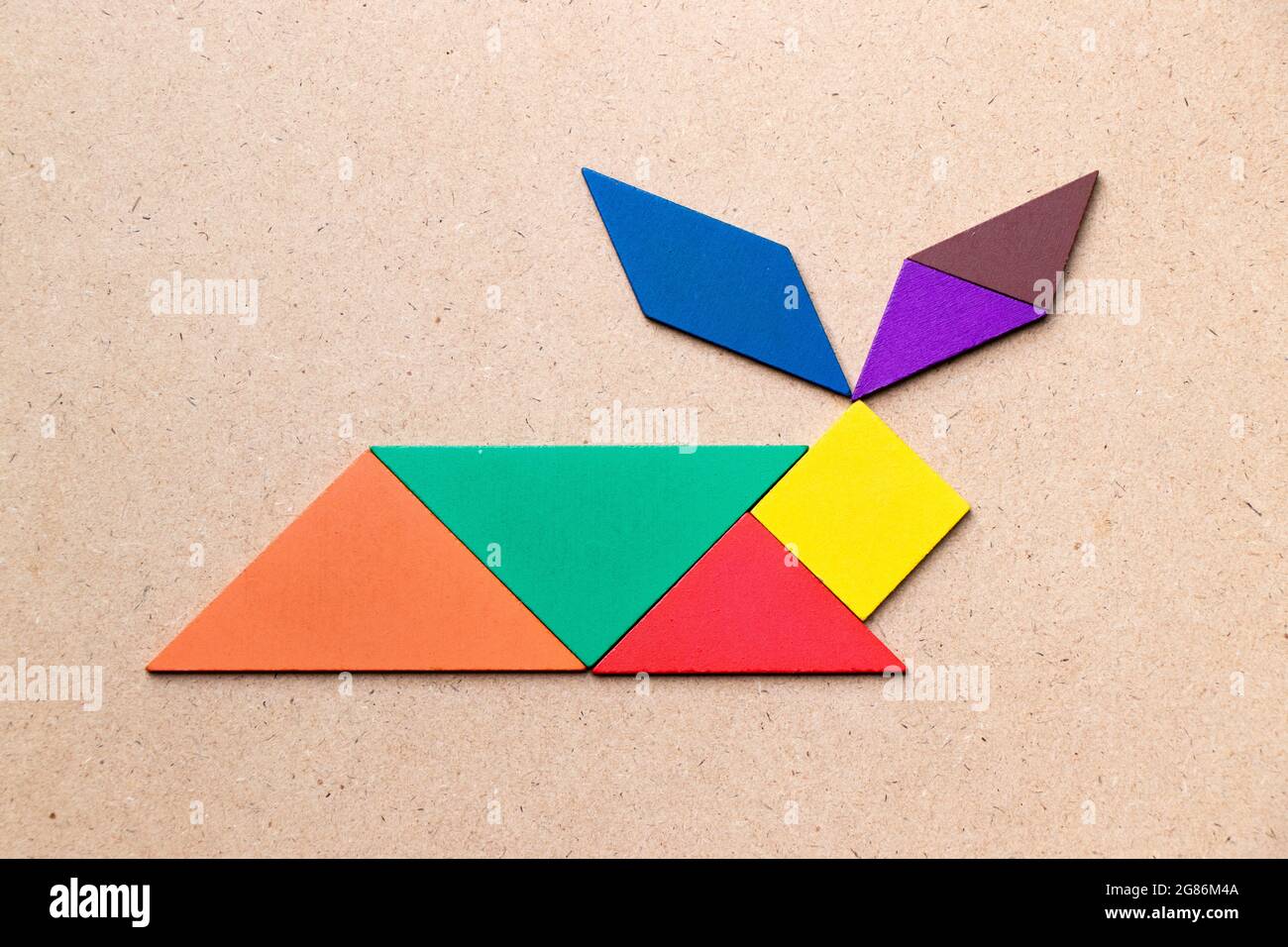 Color tangram in rabbit shape on wood background stock photo