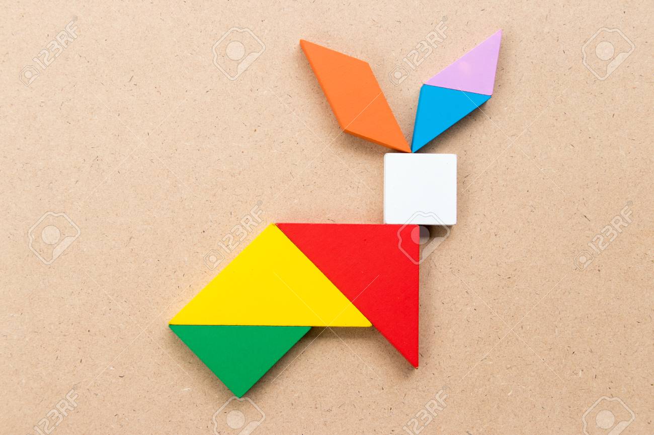 Color tangram puzzle in rabbit shape on wood background stock photo picture and royalty free image image