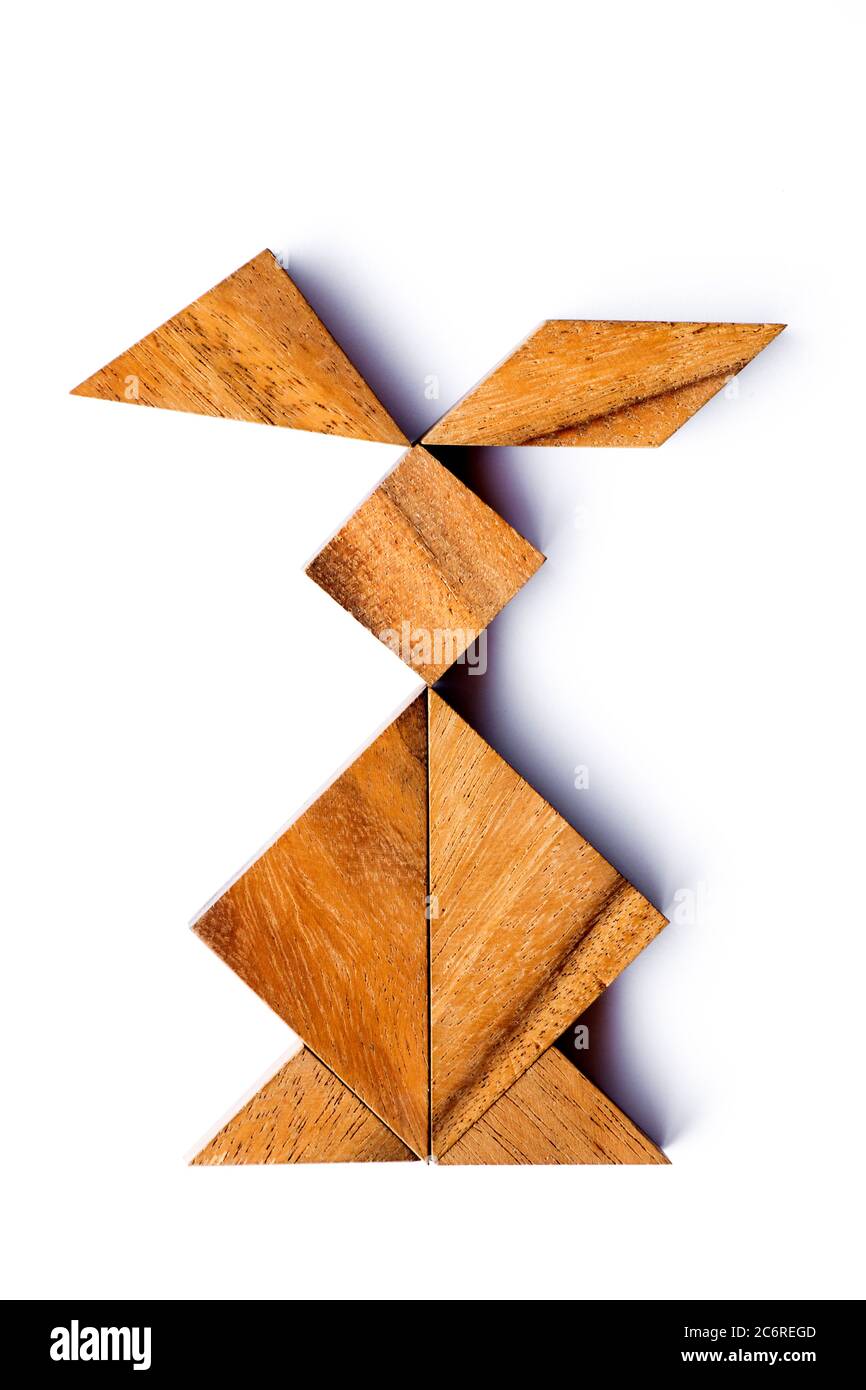 Color tangram in rabbit shape on wood background stock photo