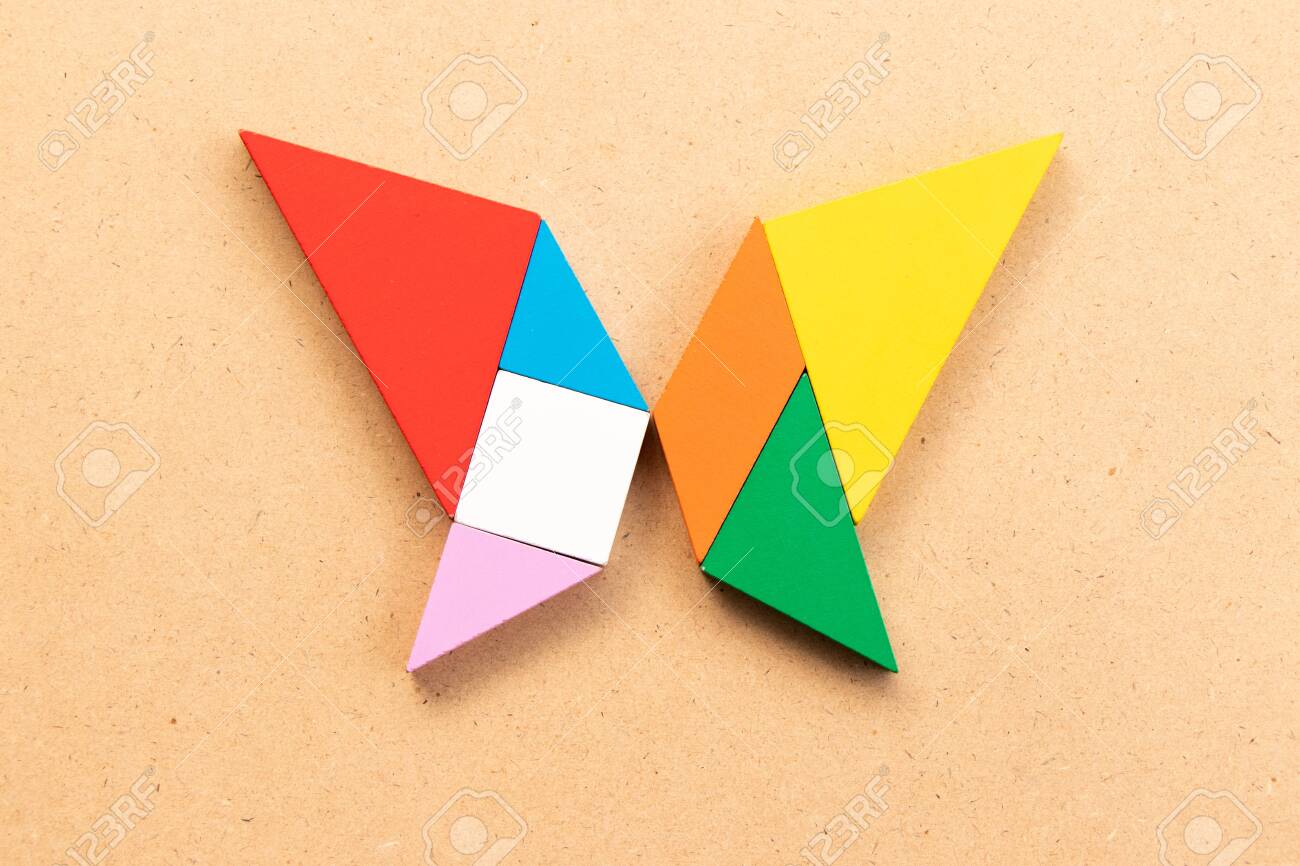 Color tangram puzzle in butterfly shape on wood bacground stock photo picture and royalty free image image