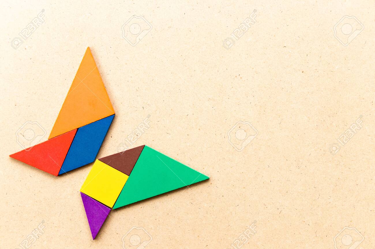 Color tangram puzzle in butterfly shape on wood background stock photo picture and royalty free image image