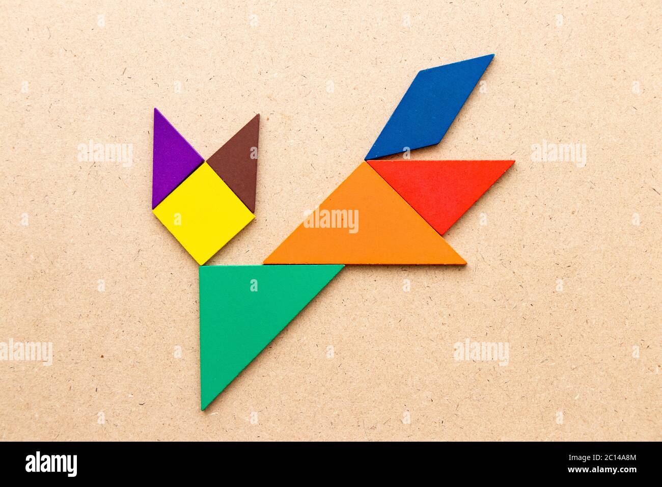 Color tangram running cat or fox puzzle in shape on wood background stock photo