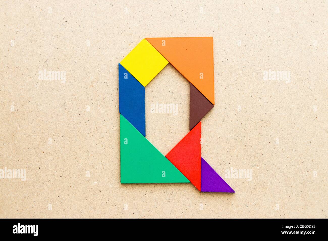 Tangram puzzle in alphabet letter o shape on wood background stock photo