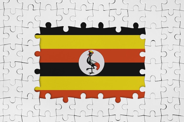 Premium photo uganda flag in frame of white puzzle pieces with missing central part