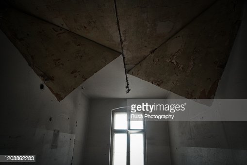 Wallpaper peeling off from ceiling in abandoned domestic interior high