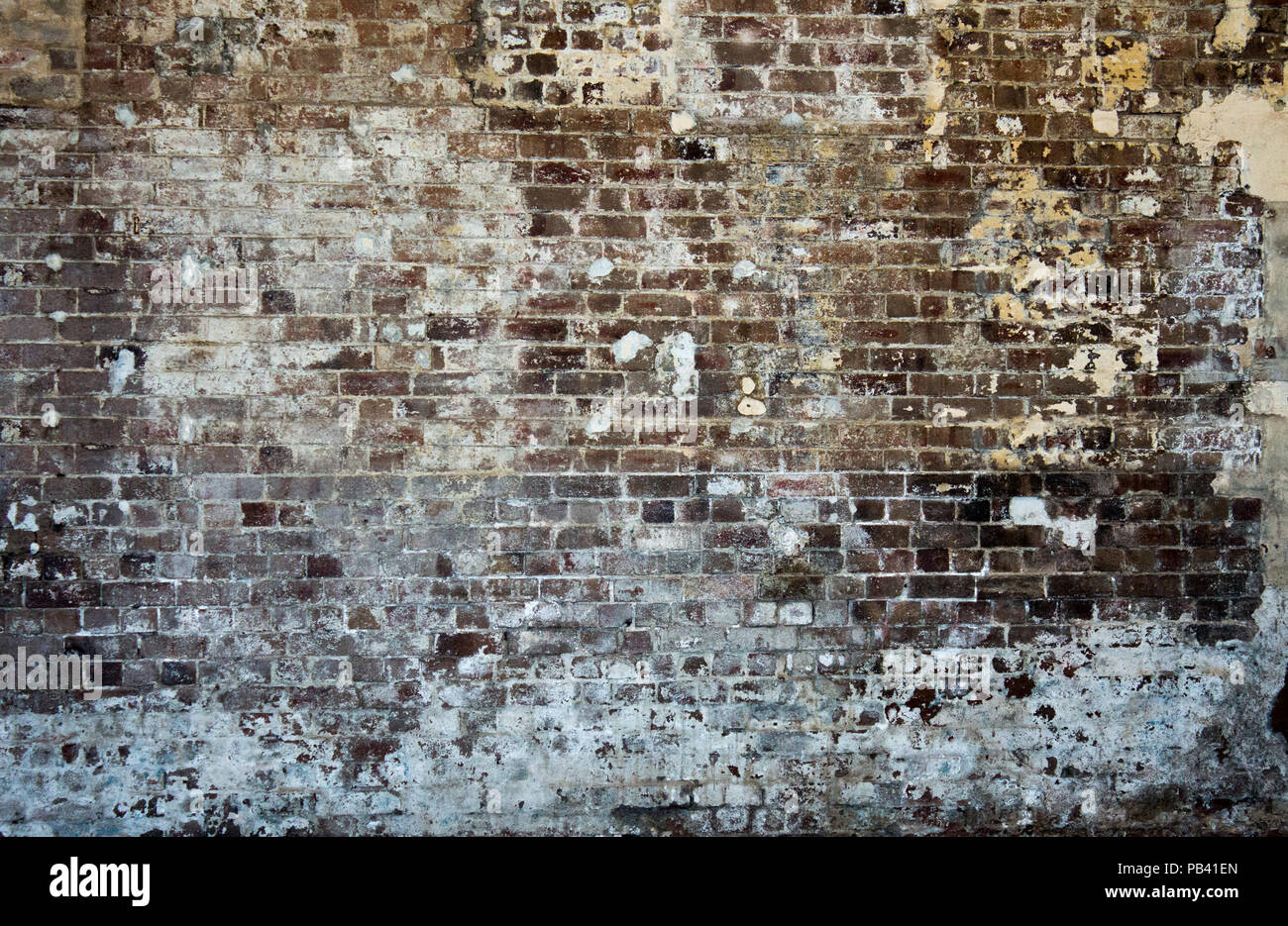 Brick stonewall old worn peeling paint background wallpaper stock photo