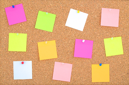 Cork board wood background with post it notes in different radiant colours cork board surface close up background of cork board wood surface with colorful notes cork table stock photo