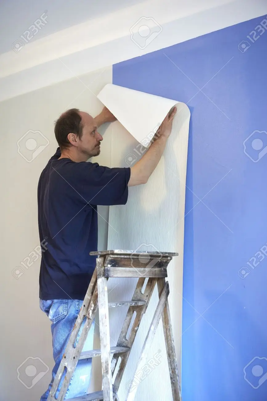 Man putting up wallpaper stock photo picture and royalty free image image