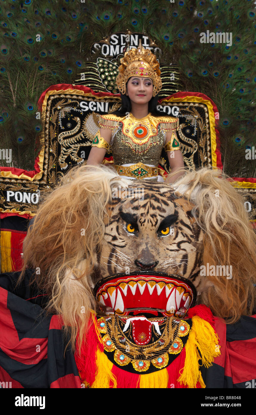 Eine weibliche reog tãnzerin sitzt auf einem sisingaan wãhrend er darauf wartet zu fãhren reog ist indonesisch traditionellen tanz aus ponorogo ostjava indonesien stockfotografie