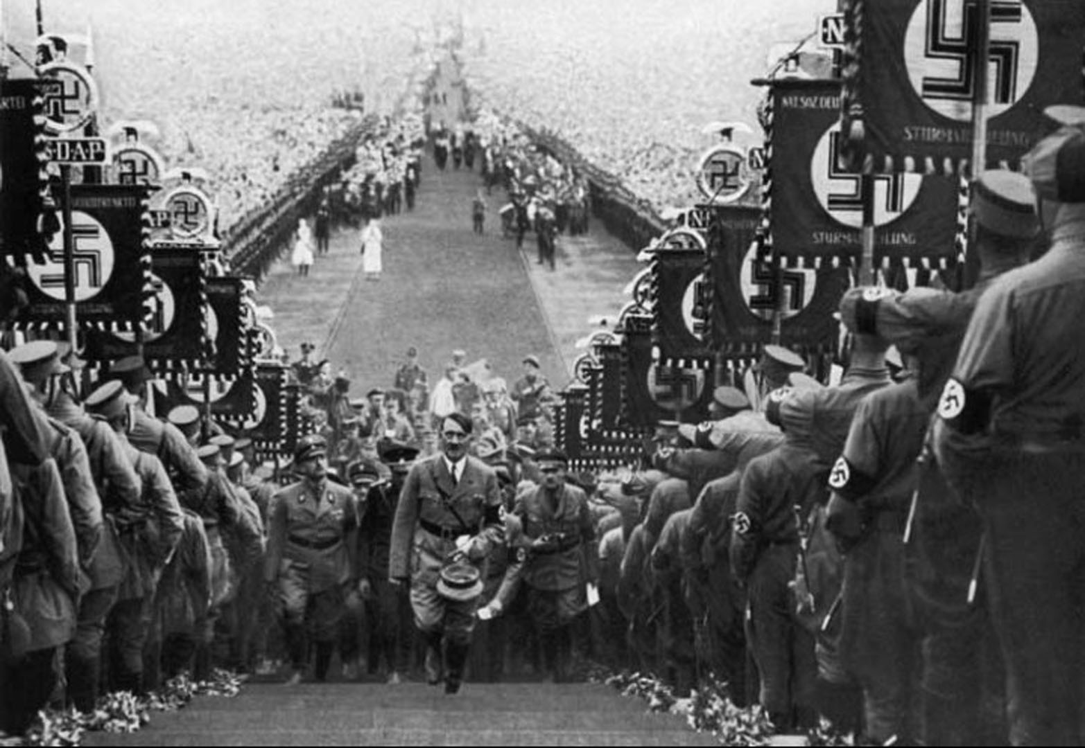 Hitler walking up steps at nazi rally