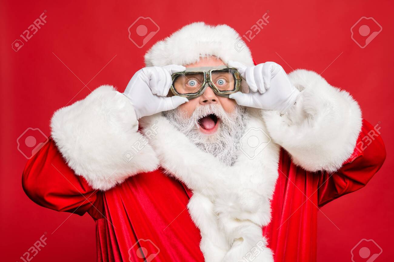 Close up photo of impressed funny santa claus touch his travel turbo glasses see winter season sales discount wear white gloves cap hat isolated over red color background stock photo picture and